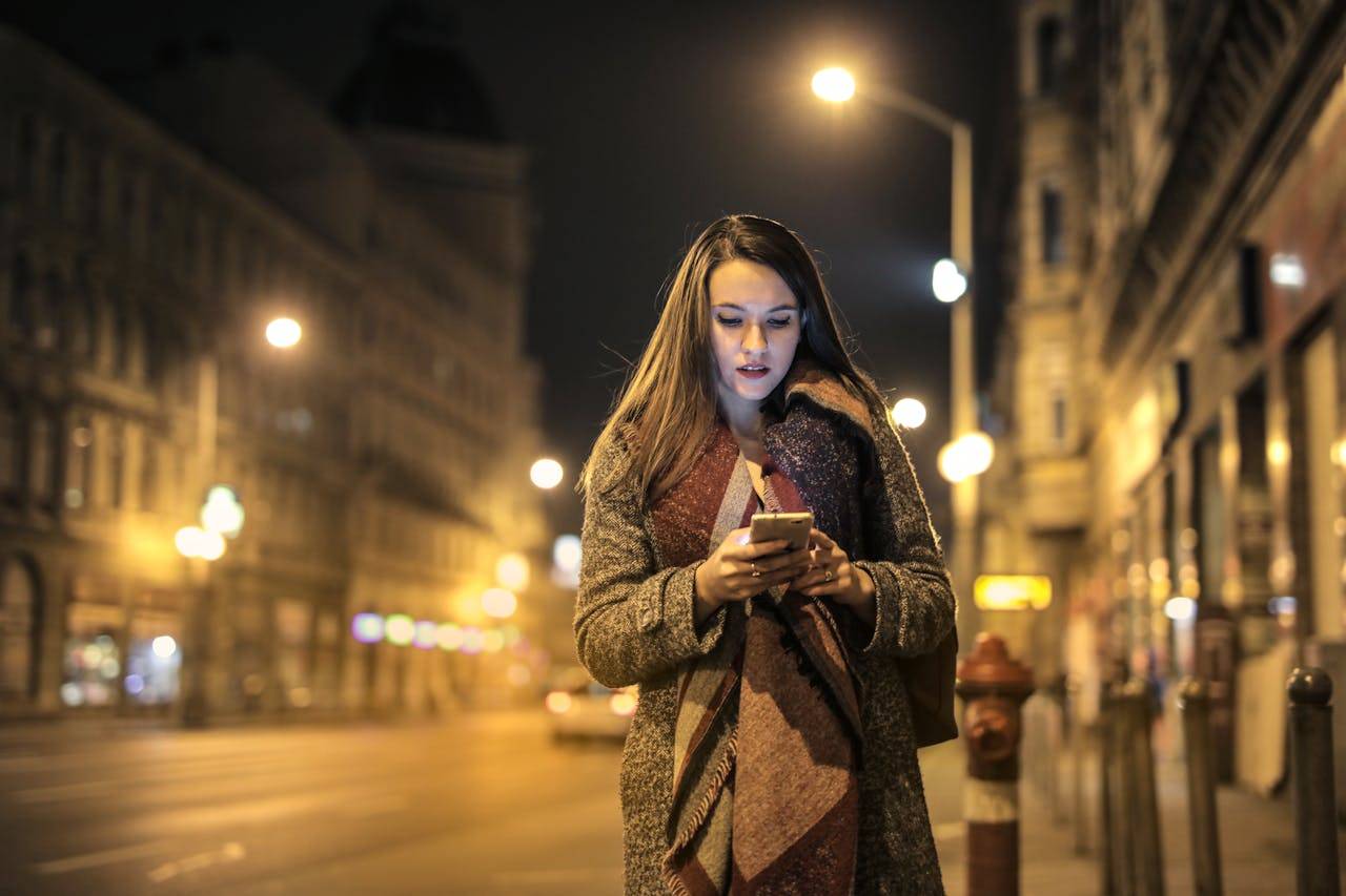 Person wearing fashionable scarf standing on a city road in another country.